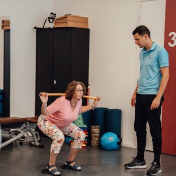 Mevrouw heeft last van heupartrose en wordt geholpen door een fysiotherapeut die revalidatie na een operatie aanbiedt.