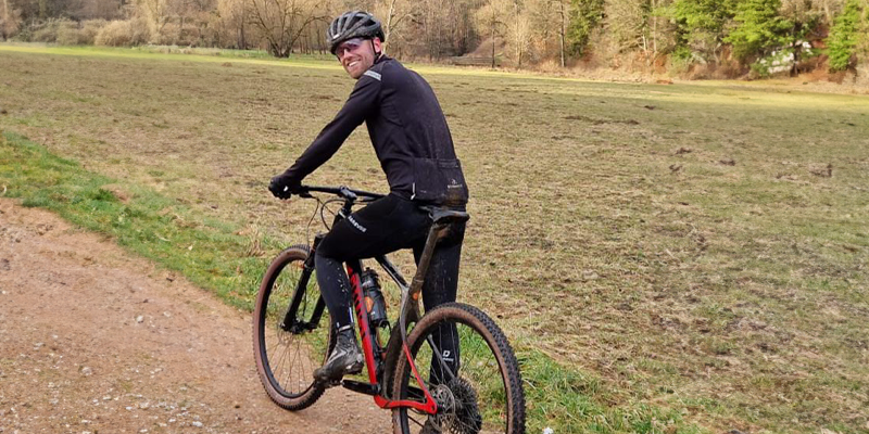 Duursporter op de fiets en in sportkleding werkt aan zijn coördinatie en mobiliteit door middel van Endurance Support.